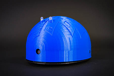 A finished blue 3D-printed Shell-E robot with a camera at the front and two LEDs on top